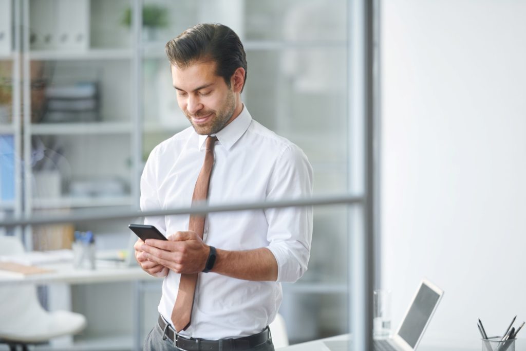 Mobile businessman scrolling through contacts in smartphone